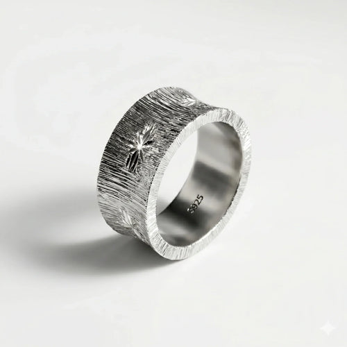 Textured sterling silver ring with engraved starburst pattern on a clean white background