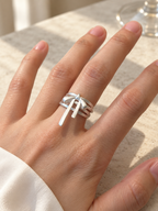 KNOTTED SIGNAL silver bow statement ring worn on the hand