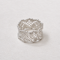 A silver ring with an intricate openwork lace-like pattern