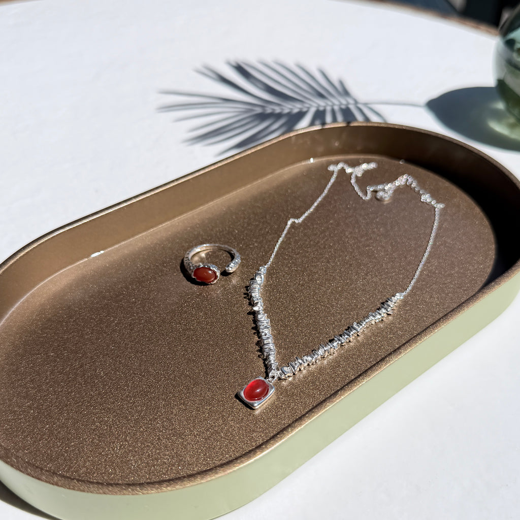 Jewelry set with silver red agate necklace and ring on a textured surface