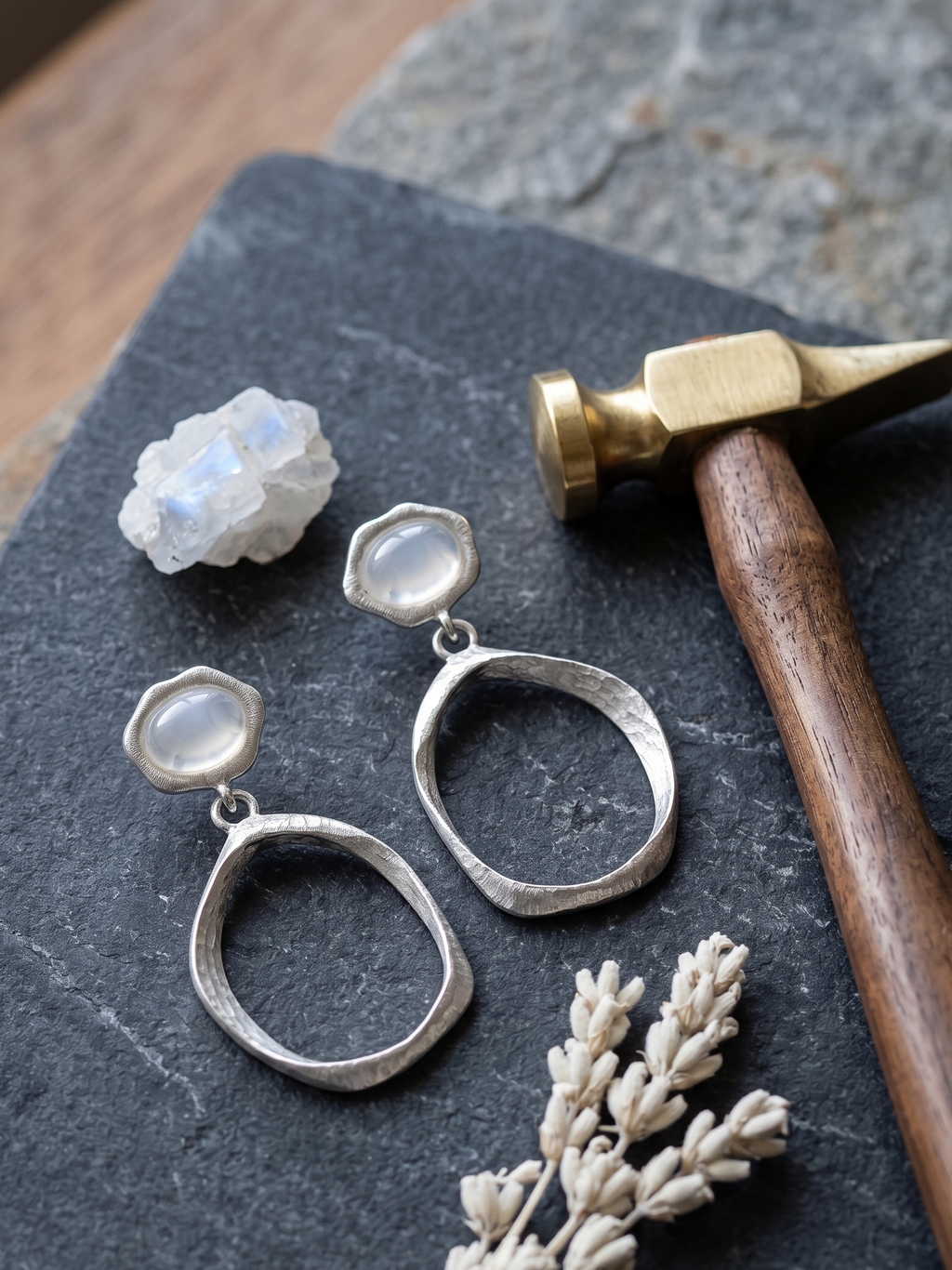 Silver drop earrings with gemstones on a dark surface