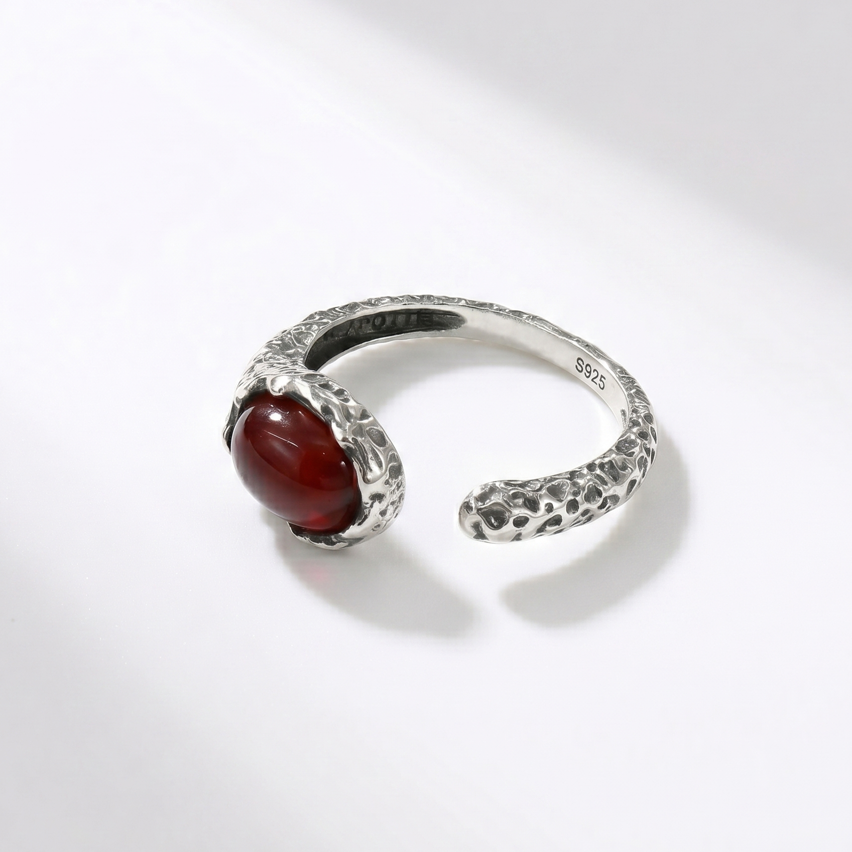 Silver ring with a red agate on a white background side view