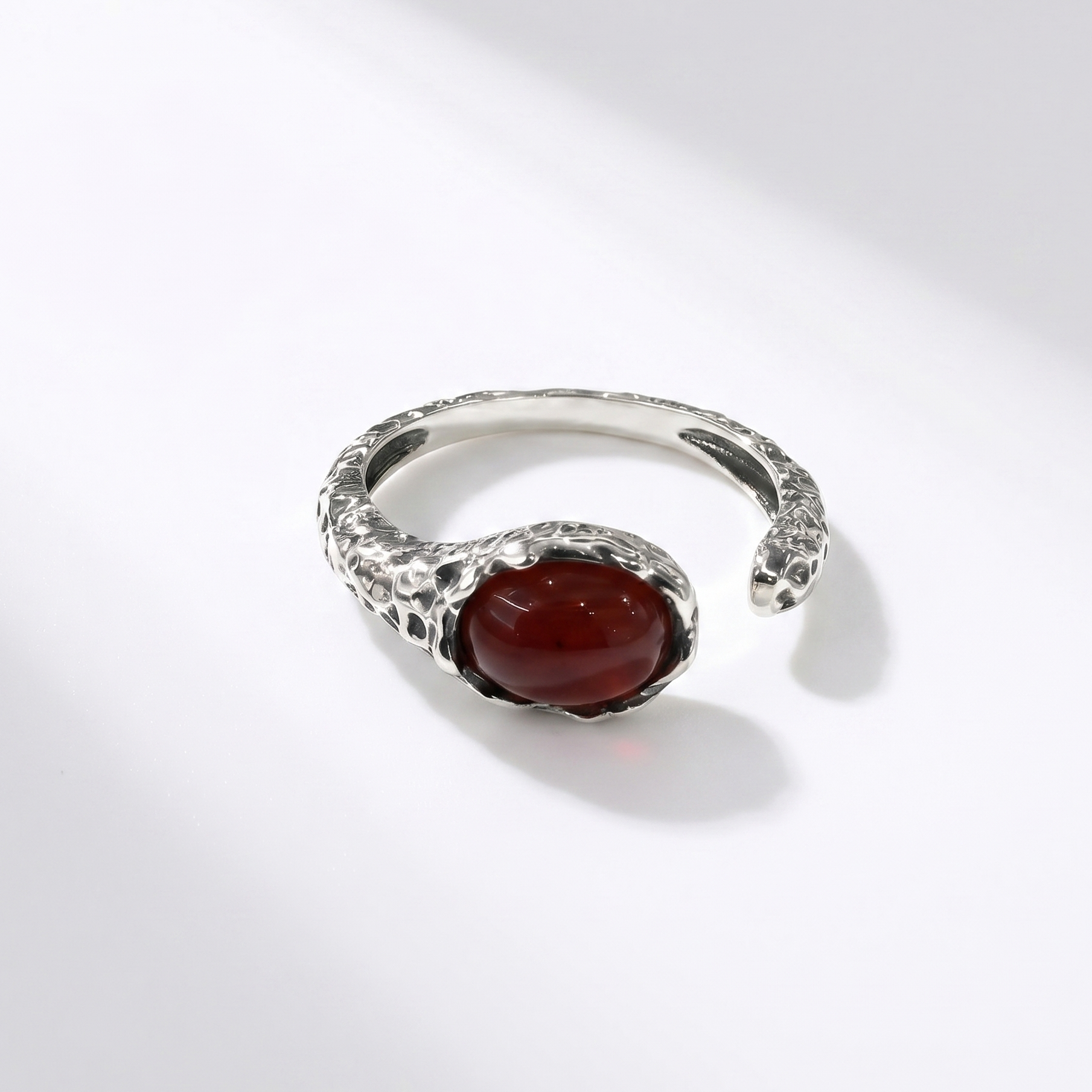 Silver ring with a red agate on a white background