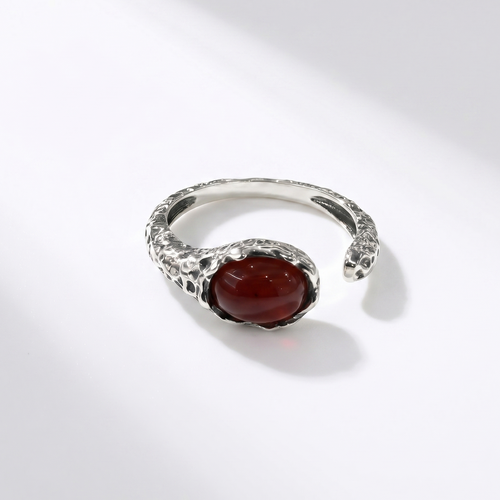Silver ring with a red agate on a white background
