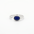 Silver ring with a blue gemstone on a white background