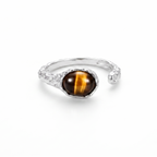 Silver ring with a tiger's eye stone on a white background