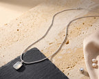 Necklace with a white agate pendant on a textured surface