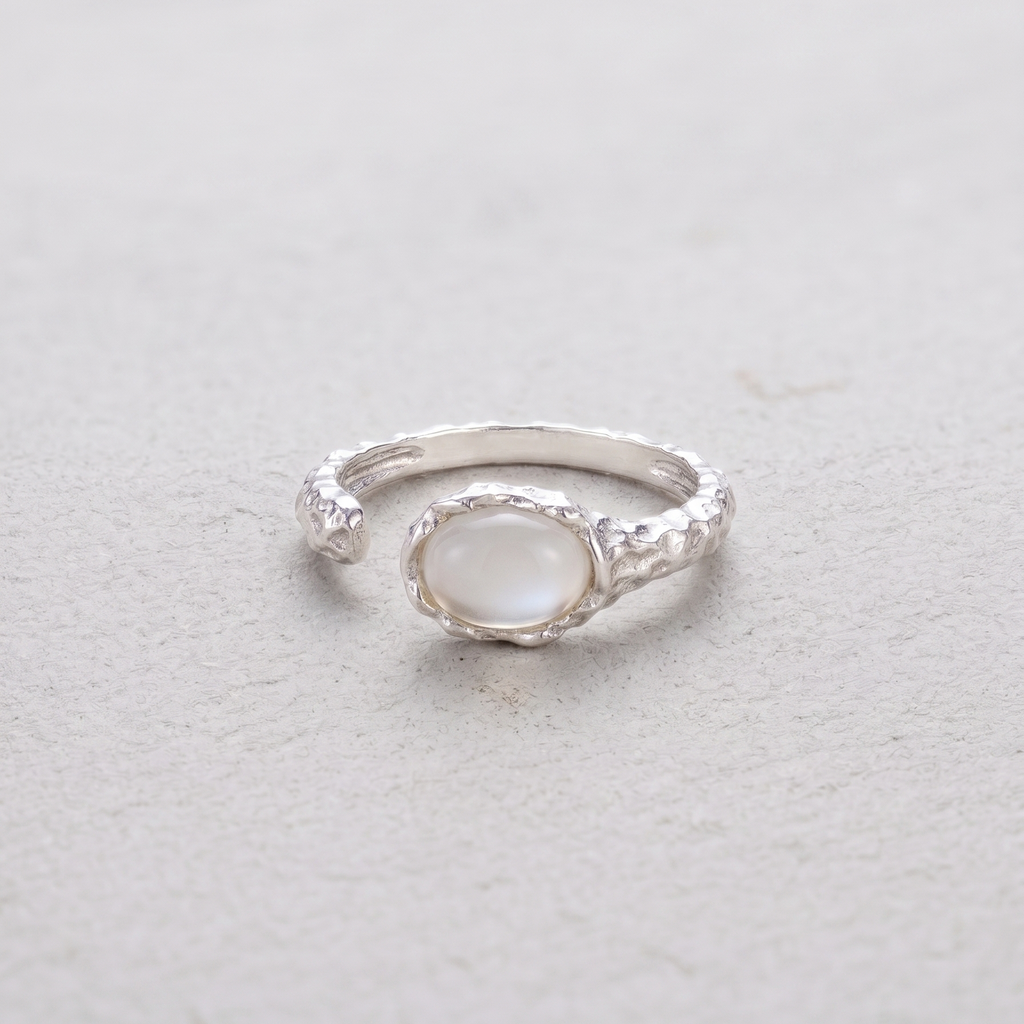 Silver ring with a white agate stone on a light gray background