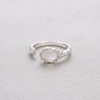 Silver ring with a white agate stone on a light gray background
