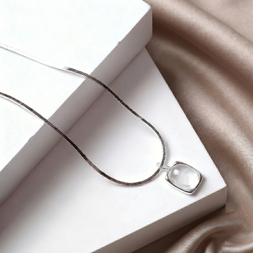Necklace with a agate pendant on a white box and beige fabric background