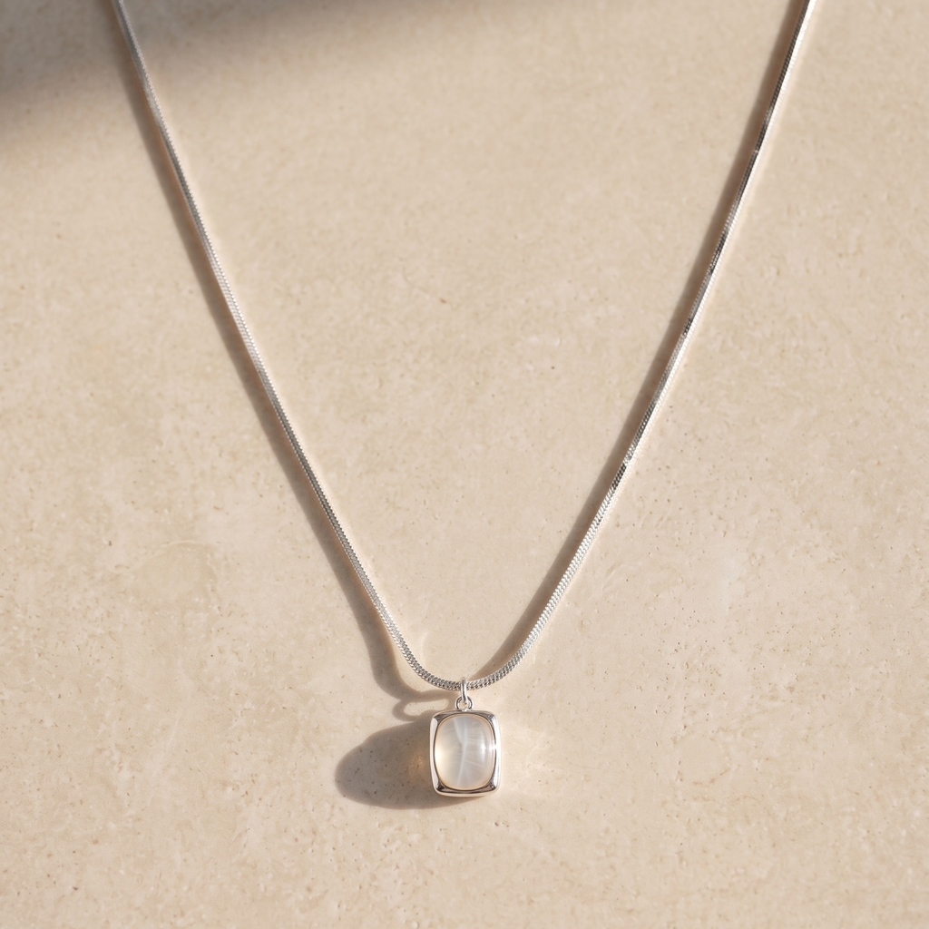 Necklace with a white agate pendant on a beige background