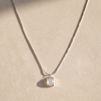 Necklace with a white agate pendant on a beige background